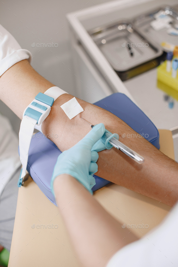 Nurse taking blood sample from patient at the doctors office Stock